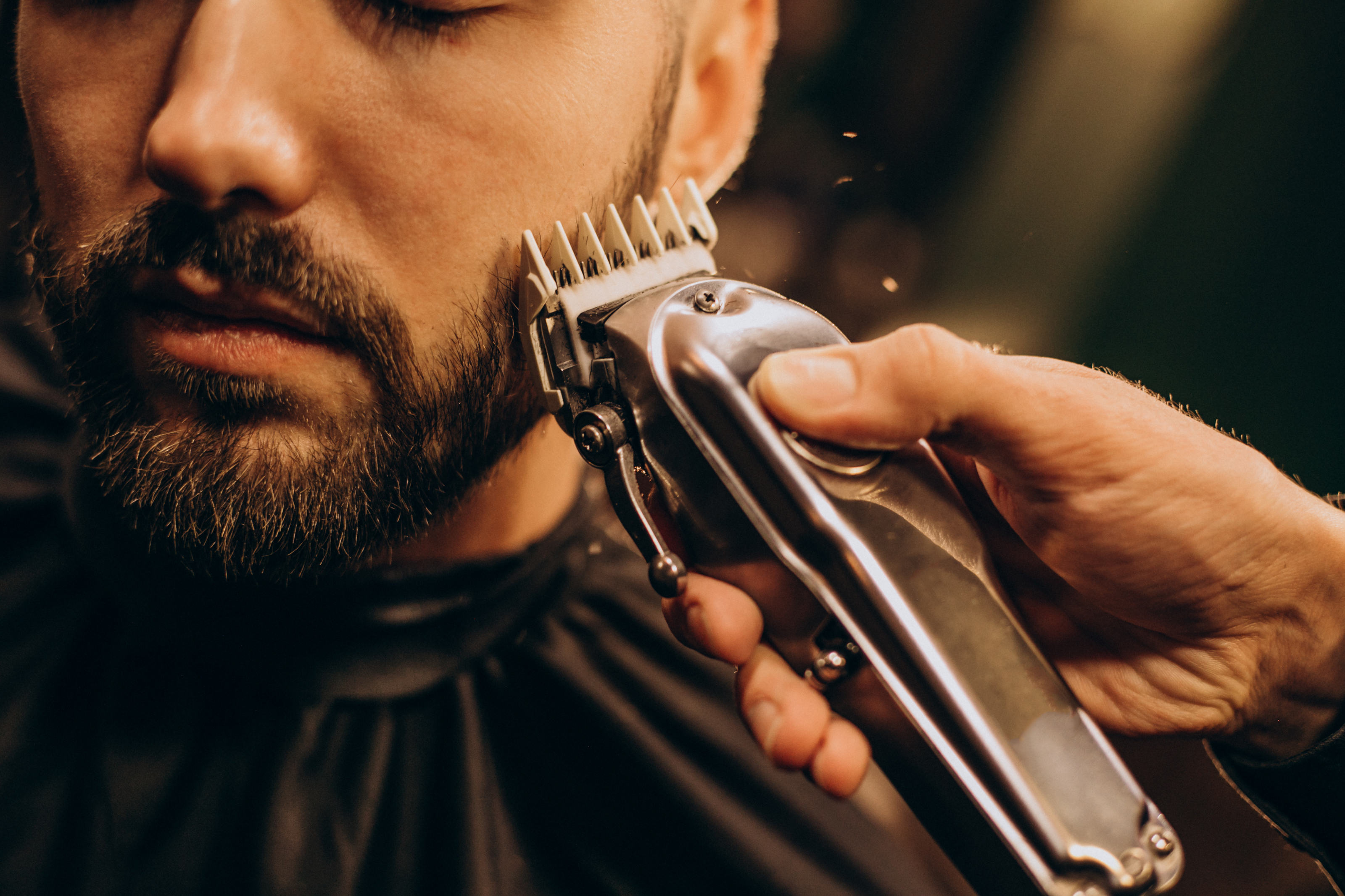 Barbero recortando la barba de un cliente